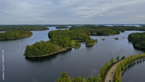 Aerial view of of small islands on a blue lake Saimaa. Landscape with drone. Blue lakes, islands and green forests from above on a cloudy summer morning. Lake landscape in Finland.	
