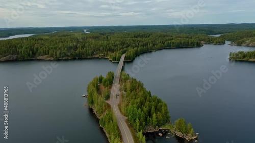 Aerial view of of small islands on a blue lake Saimaa. Landscape with drone. Blue lakes, islands and green forests from above on a cloudy summer morning. Lake landscape in Finland.	