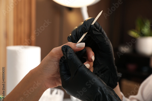 Fotografie Professional manicurist working with client in salon, closeup
