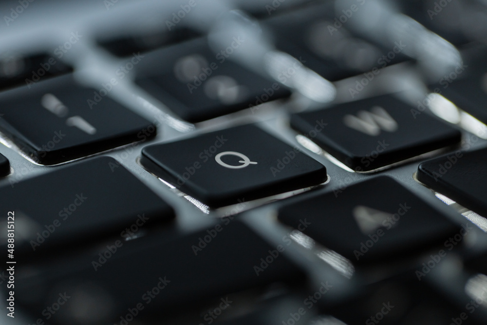 Modern backlit laptop keyboard with button Q, close-up. Concept programming Modern backlit laptop keyboard with button Q, close-up. Concept programming