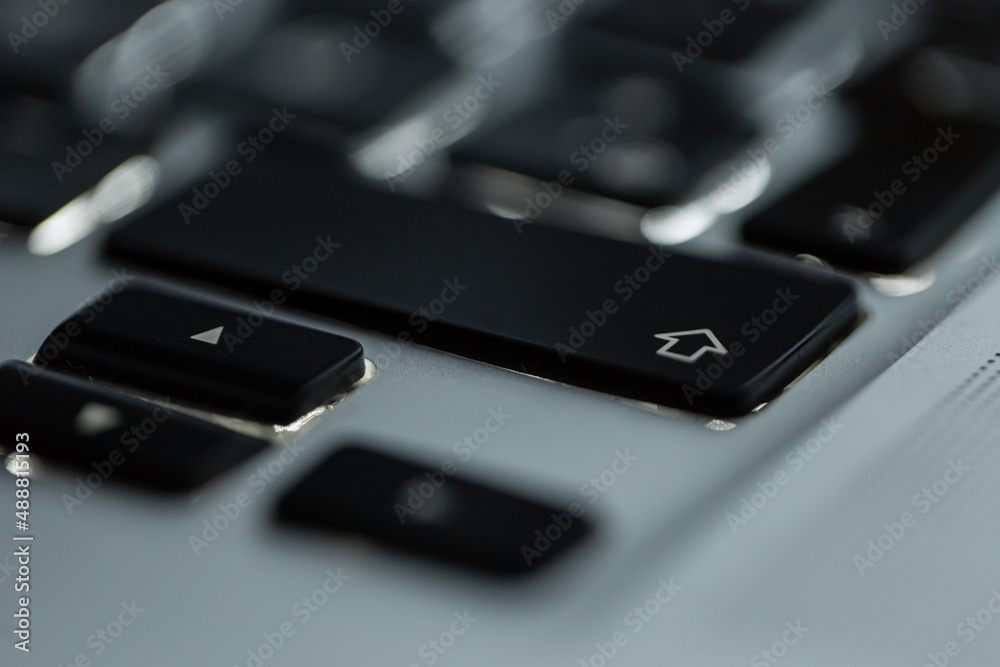 Backlit computer keyboard with focus on shift button, close-up Backlit computer keyboard with focus on shift button, close-up