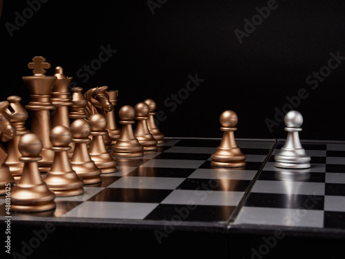 One chess piece stands against a full set of chess pieces. The concept of strategy  planning and decision-making