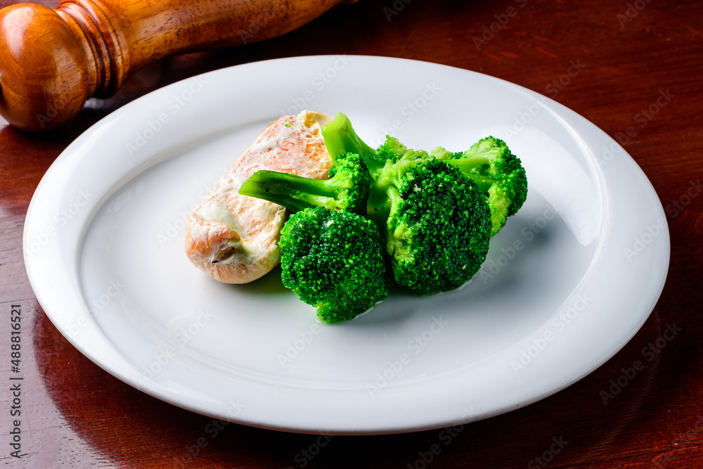 Steam salmon, broccoli, paleo, keto or fodmap diet. White plate on table