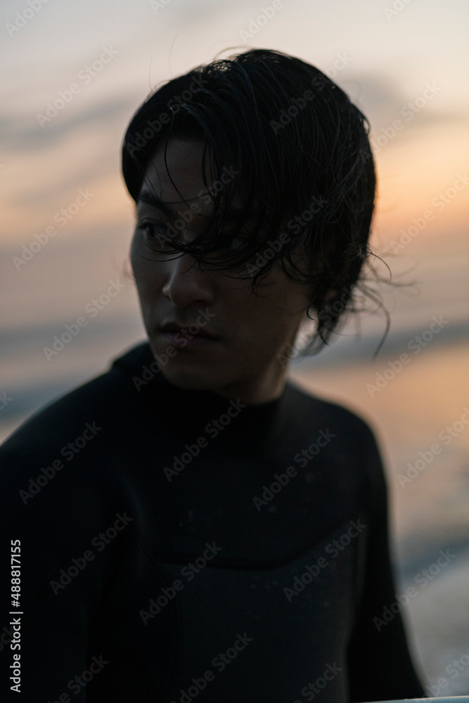 Fototapeta premium 朝の海でサーフィンをする男性