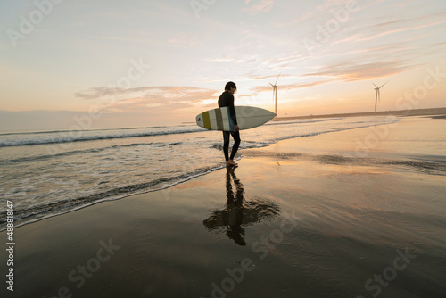 朝の海でサーフィンをする男性