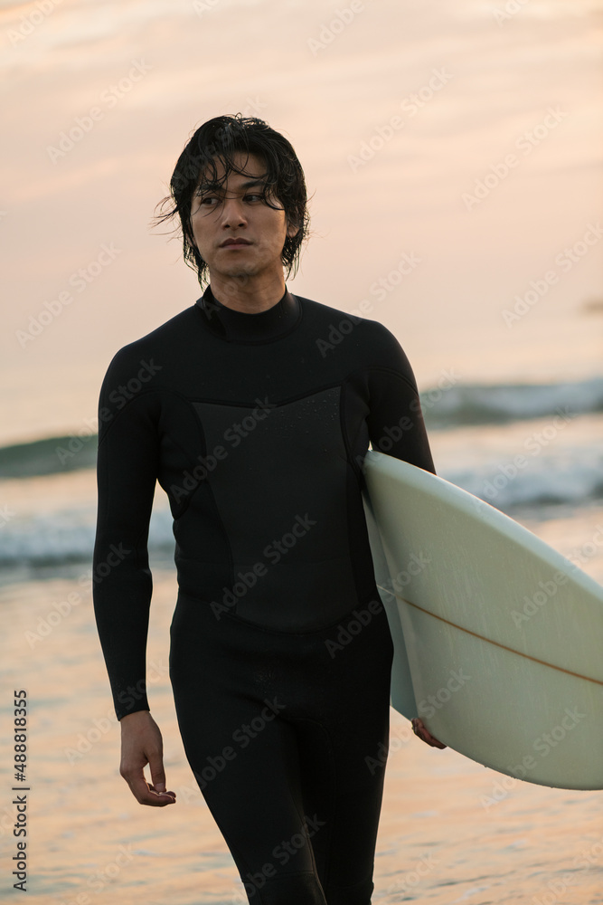 Fototapeta premium 朝の海でサーフィンをする男性
