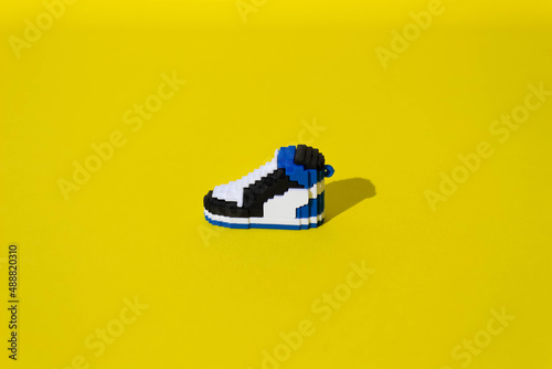 Sneakers with shadow on yelow background photo