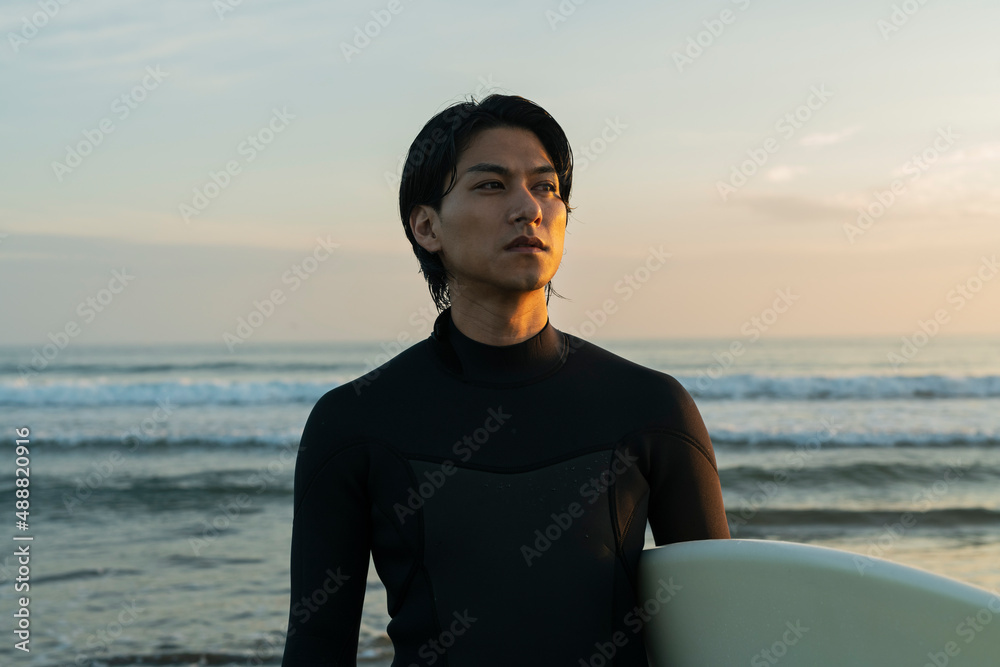 Fototapeta premium 朝の海でサーフィンをする男性