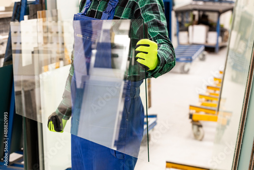 The glazier carries a pane of glass in his hands, the Glass Factory photo