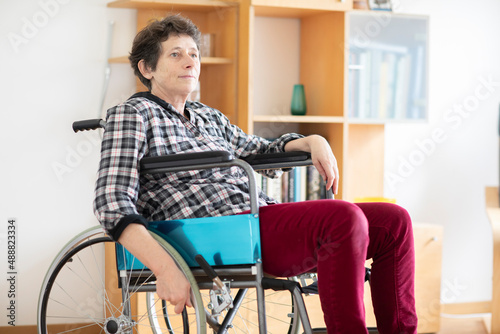 Foto Ältere Frau im Rollstuhl sitzt zu Hause