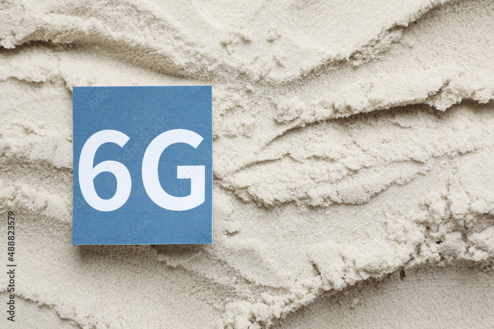 6G technology, Internet concept. Card on white sand, top view. Space for text 6G technology, Internet concept. Card on white sand, top view. Space for text
