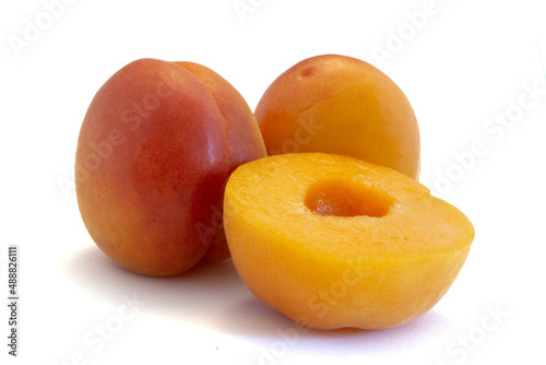 Two whole apricots and a sliced ​​apricot isolated on white background