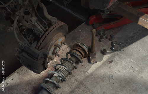 Suspension shock absorber rusty lies under the brake disc of the car on the ground