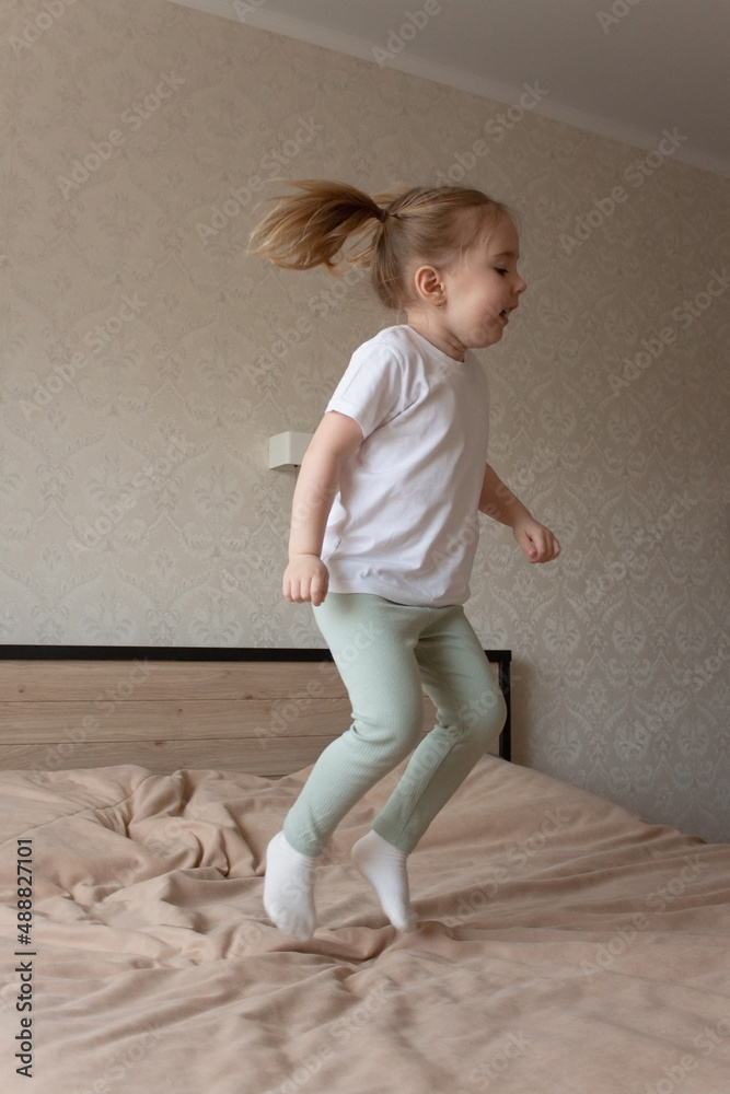 little girl jumping cheerfully on the bed little girl jumping cheerfully on the bed