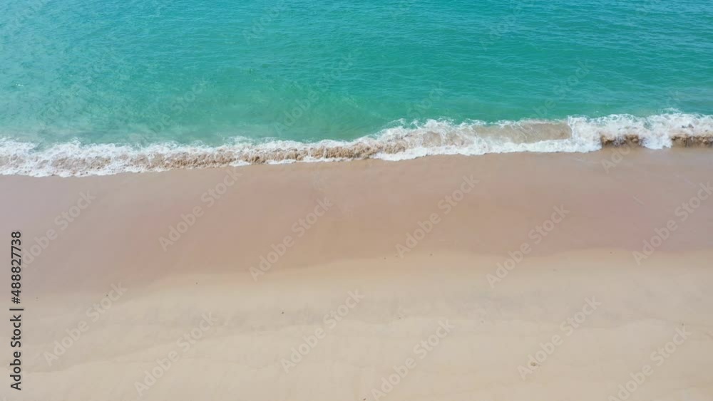 aerial top view sea waves seamless loop on the white sand beach. .Wave after wave swept towards the shore. .green sea, white bubble waves,and clear sand landscape. aerial top view sea waves seamless loop on the white sand beach. .Wave after wave swept towards the shore. .green sea, white bubble waves,and clear sand landscape.