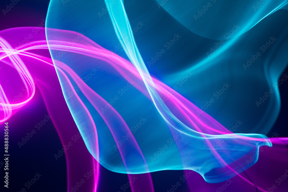 Obraz premium Neon blue and pink led lines on a dark night background. Vapor wave futuristic wallpaper.