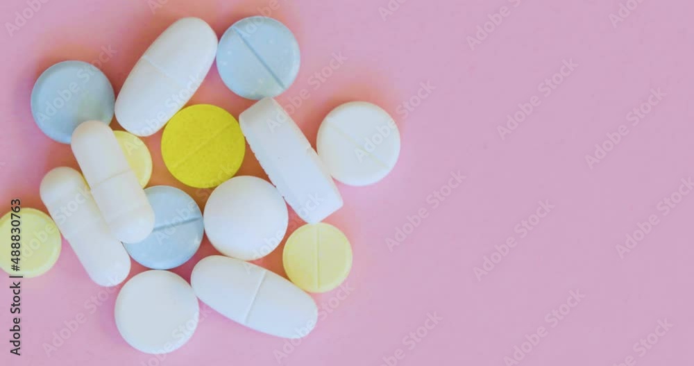 Top view, rotation - pills and capsules on a pink background. Top view, rotation - pills and capsules on a pink background.
