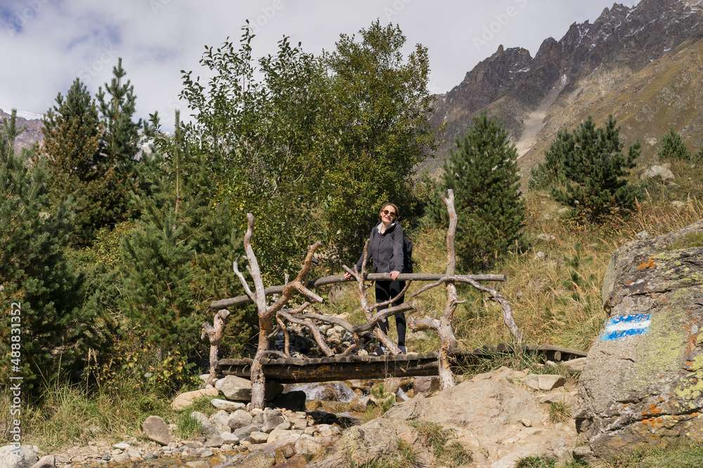 Naklejka premium Woman traveller, tourist with a backpack in mountains. Active life concept.