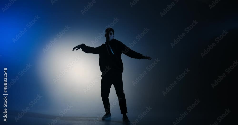 Young man break dancing in blue light background Young man break dancing in blue light background