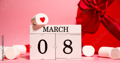 Women's day creative banner with heart shaped gifts, marshmallows and calendar with 8 march date photo