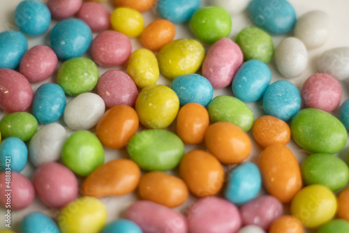 Background made of colorful candy dragee  multi-colodes glazed raisins. Seamless texture of multi-colored glazed raisins backdrop. Top view.