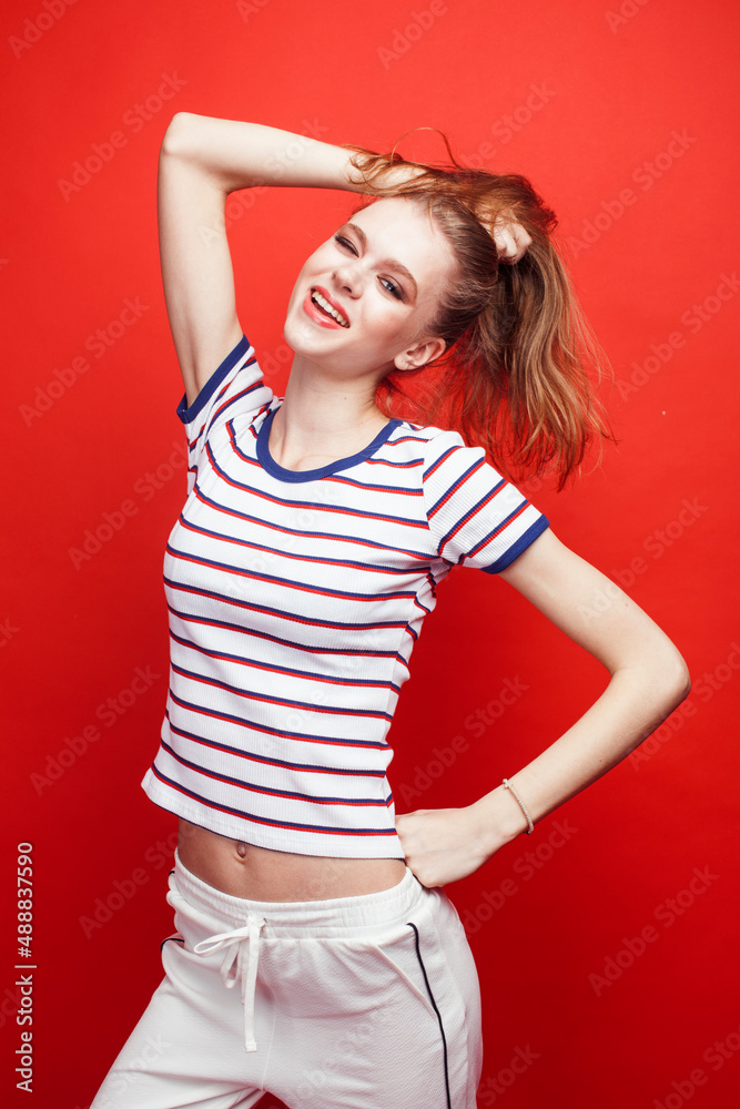 young pretty emitonal posing teenage girl on bright red background, happy smiling lifestyle people concept