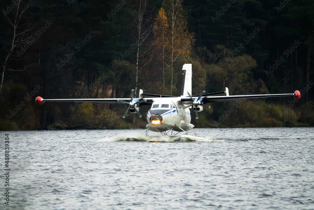 The Twinengine seaplane a seaplane rises from water, from the forest