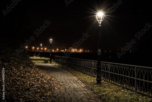 alejka nad brzegiem rzeki oświetlona latarniami