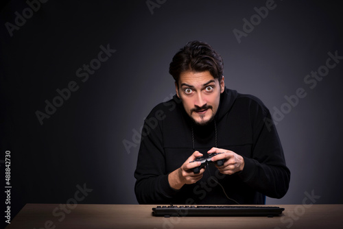 Young male gamer on grey background