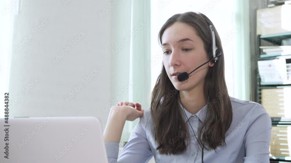 Young woman wearing headphones, communicating online via laptop, explaining, teaching. Distance education, businesswoman advising client Young woman wearing headphones, communicating online via laptop, explaining, teaching. Distance education, businesswoman advising client
