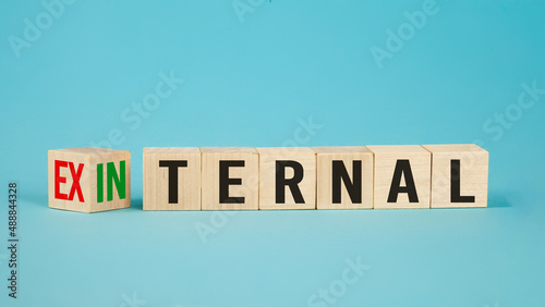 External and internal on wooden cubes, dice or blocks showing the words external and internal on blue background.Business concept.