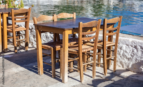 Outdoor seaside tavern, fish and sea food taverna empty table and chair, summer sunny day. Greece