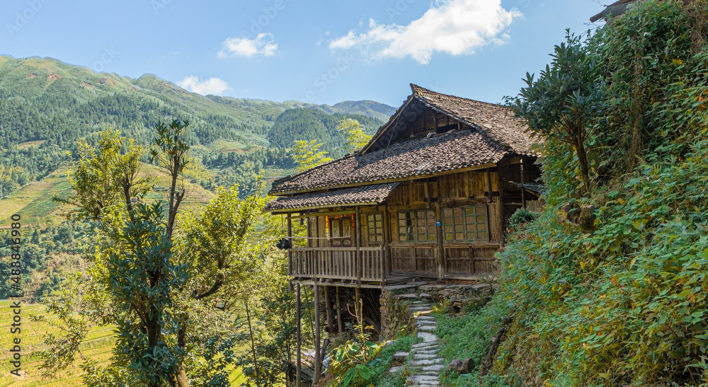 Traditional wooden farm house amidst the Longsheng rice terraces in summer, Guangxi Province, China

