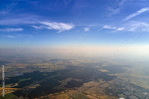 Aerial view of farm fields and distant scattered houses in rural area
