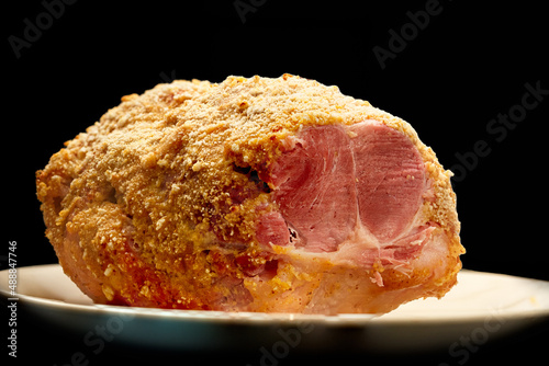 Whole semi boneless pork ham isolated on black background.