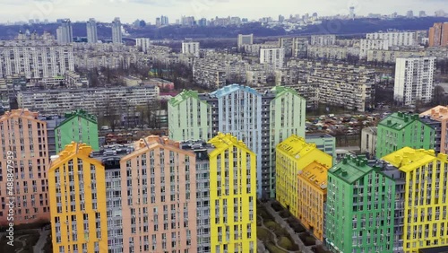 Fly over multi-colored residential buildings in Kiev in cloudy weather. Aerial drone flight.