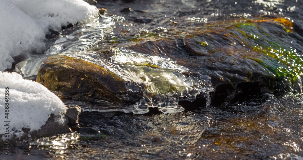 Flowing river water among snowdrifts in winter Flowing river water among snowdrifts in winter