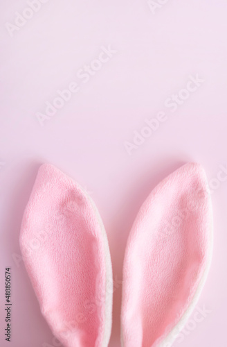 Easter vertical greeting card .Pink eggs and bunny ears on pink pastel background with copy spase . Easter minimal concept. Flat lay. advertising concept .