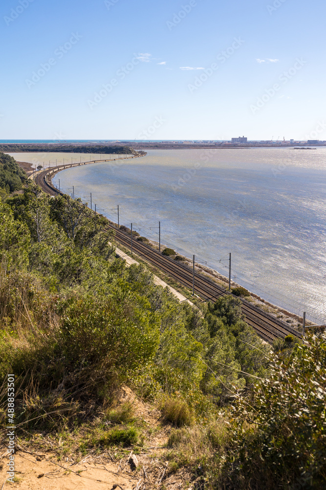 Vue sur l’Étang de Bages-Sigean bordé par une ligne de chemin de fer depuis la Réserve naturelle régionale de Sainte-Lucie à Port-la-Nouvelle (Occitanie, France)
