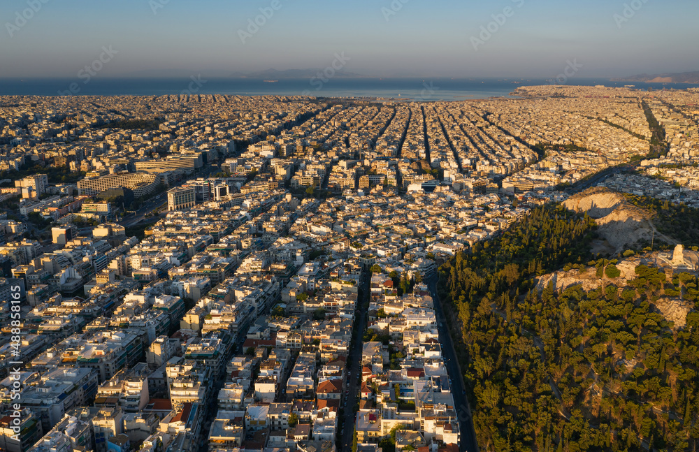 Sunrise, top view of the famous Athens, rectangular streets and a grid of buildings, quarters directed towards the sea, mountains on the horizon, Greece