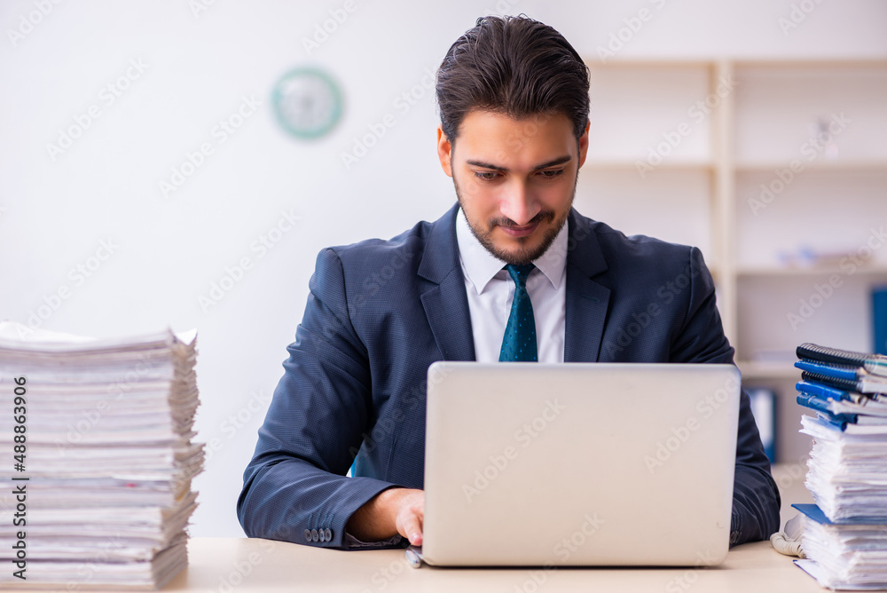 Young businessman employee and too much work in the office Young businessman employee and too much work in the office
