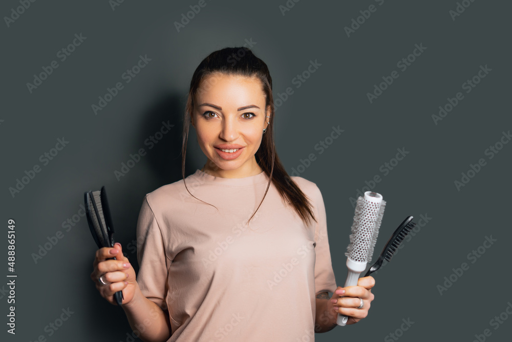 Young woman in apron on grey background. Hairdresser concept Young woman in apron on grey background. Hairdresser concept