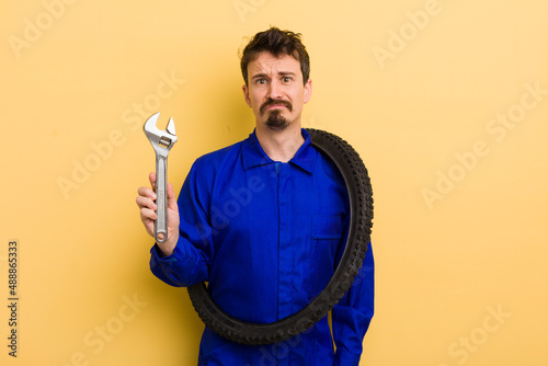 feeling sad and whiney with an unhappy look and crying. bike repairman concept photo