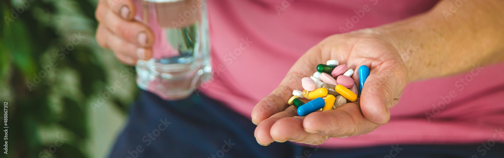 An old woman holds pills in her hands. Selective focus. An old woman holds pills in her hands. Selective focus.