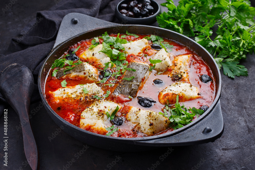 Traditional Spanish seafood zarzuela de pescado with fish served in red sauce as top view in design pot Traditional Spanish seafood zarzuela de pescado with fish served in red sauce as top view in design pot