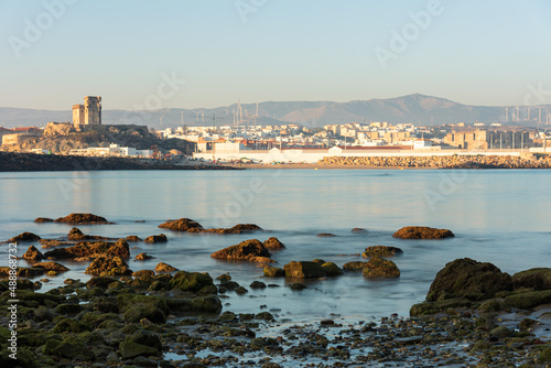 Long exposure view of the coastal town of Tarifa from the rocky beach of the Island of Tarifa at sunset, Cadiz, Andalusia, Spain