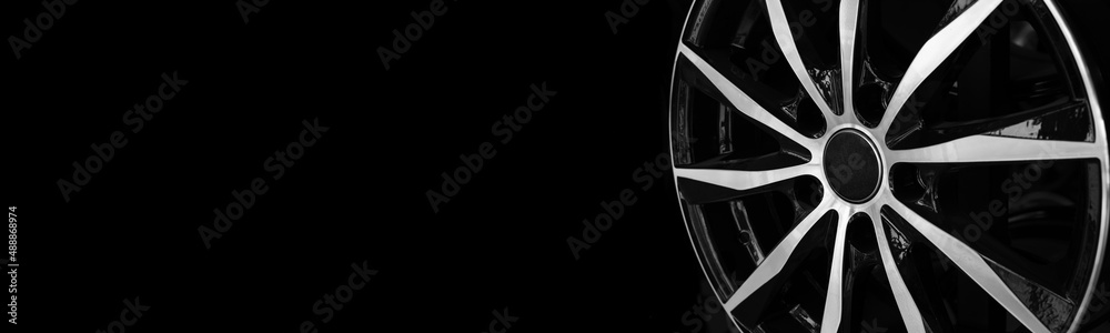 Automotive alloy wheel close-up on a black background. Showcase template, billboard with place for text.
