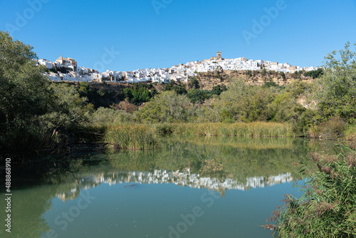 City landscape at daylight of the beautiful andalusian white town of Arcos de la Frontera reflected in the water of Guadalete river  Cadiz  Andalusia  Spain