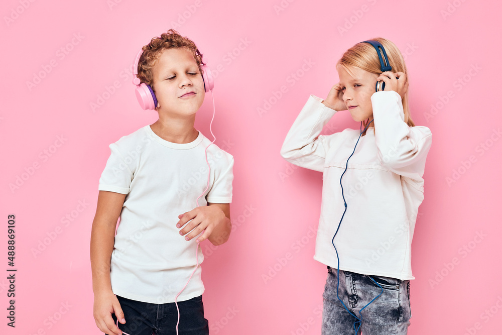 Stylish little boy and cute girl dancing with headphones entertainment studio childhood Stylish little boy and cute girl dancing with headphones entertainment studio childhood