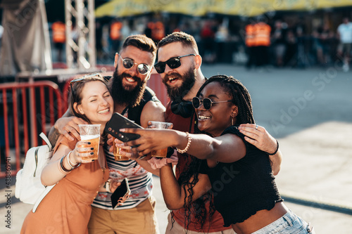 Group of friends taking selfie with a smartphone on a music festival